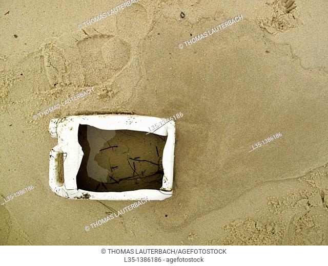 Cut-open plastic container on the beach