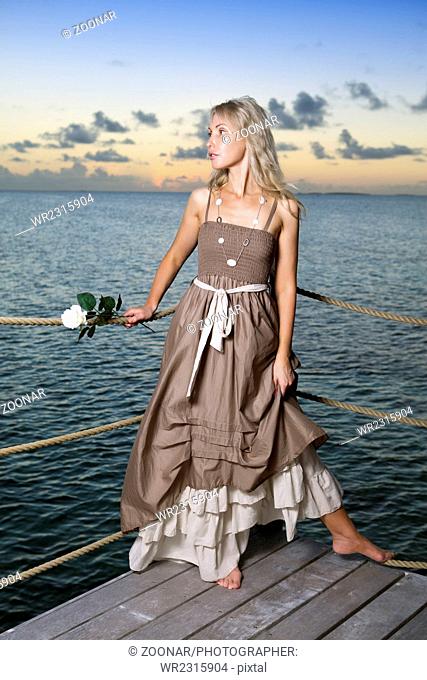 woman in a long dress on a wooden platform over th