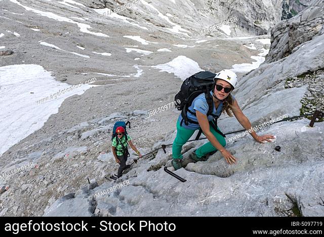 Female mountaineers climbing rock face, secured route from Simonyhütte to Adamekhütte, rocky alpine terrain, Salzkammergut, Upper Austria, Austria, Europe