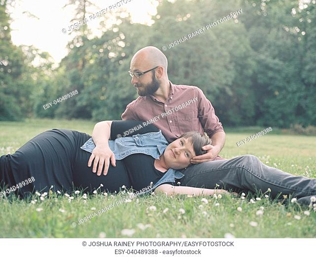 Man and a pregnant woman in a field in Oregon while the girl is in her third trimester. The couple is married and this husband and wife are expecting their...