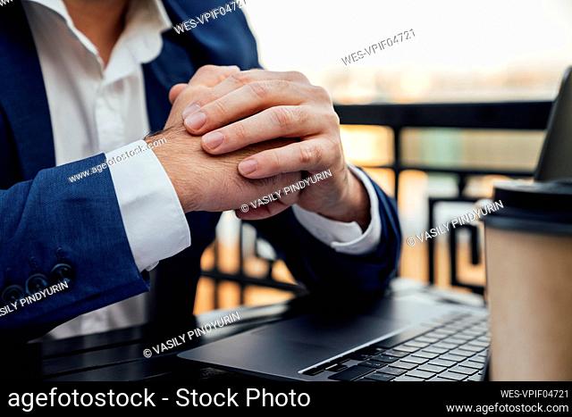 Businessman with hands clasped in balcony