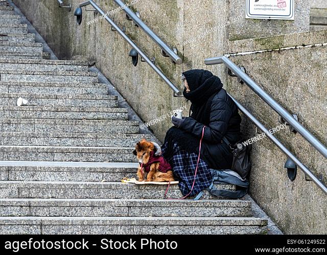 Schaerbeek, Brussels Capital Region - Belgium Woman beggar with a small dogg at the stairs of the Brussels North CCN railwaystation