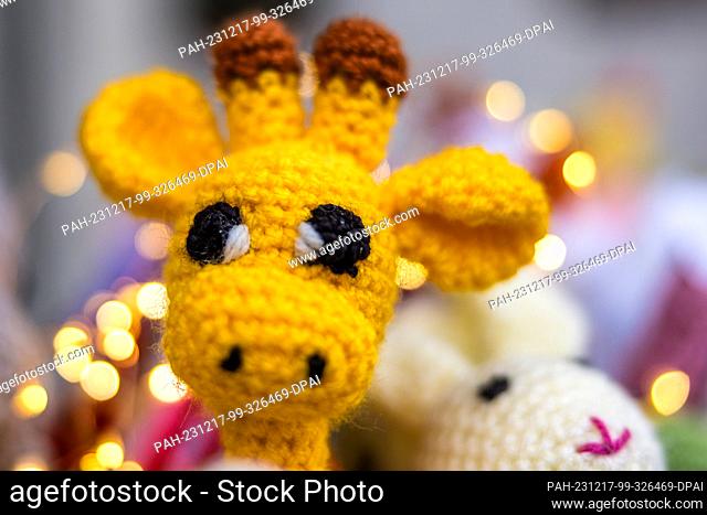 16 December 2023, Brandenburg, Leuthen: Handmade knitted dolls lie on a stall at a small Advent market. Advent and Christmas markets are also held in many...