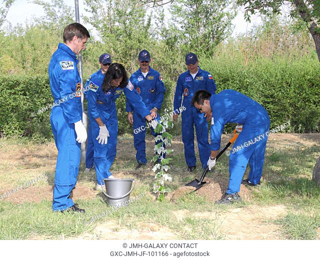 Assisted by NASA Flight Engineer Sunita Williams, Expedition 3233 Flight Engineer Aki Hoshide of the Japan Aerospace Exploration Agency plants a tree in his...