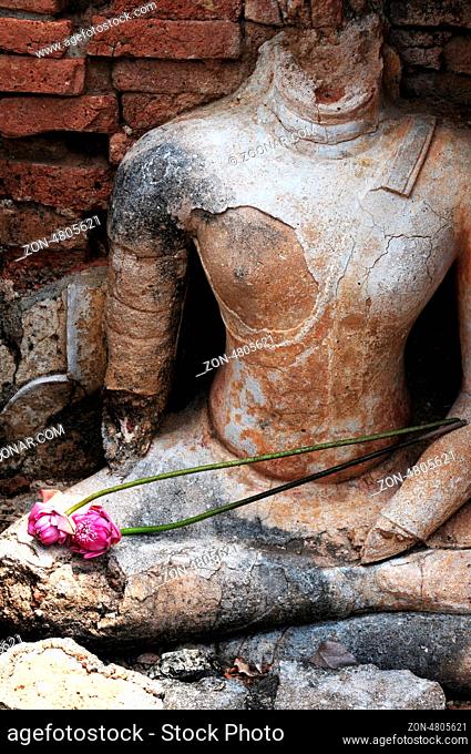 Statue of a deity with lotus flowers in the Historical Park of Sukhothai, Thailand