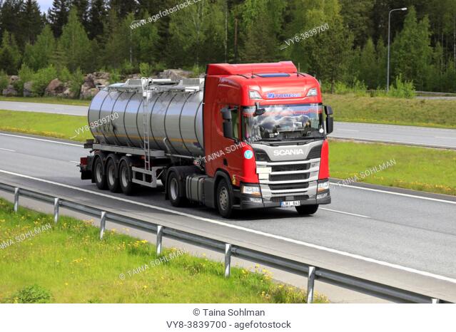 Red Scania R450 semi tanker truck Tomega at speed on motorway in Finland. Salo, Finland. May 28, 2021