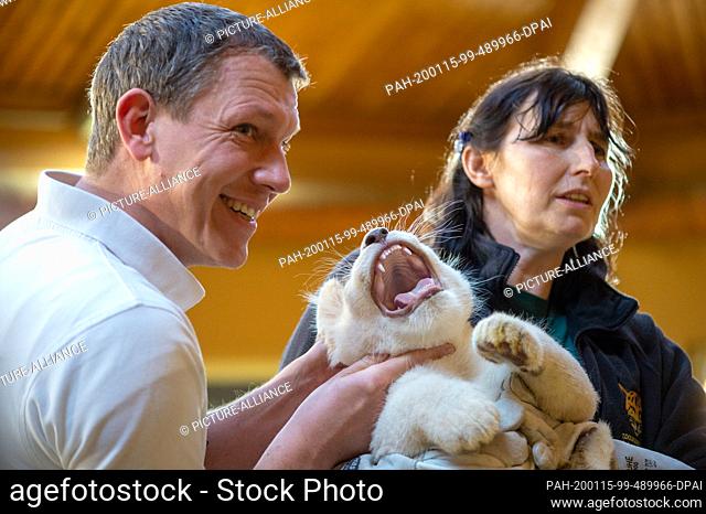 15 January 2020, Saxony-Anhalt, Magdeburg: Veterinarian Niels Mensing (l) and animal keeper Susann Paelecke examine a small white male lion