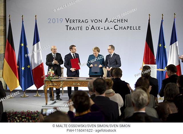 Emmanuel MACRON, President of the French Republic, and with Chancellor Angela MERKEL sign the treaty, French Foreign Minister Jean-Yves Le Drian on the left and...