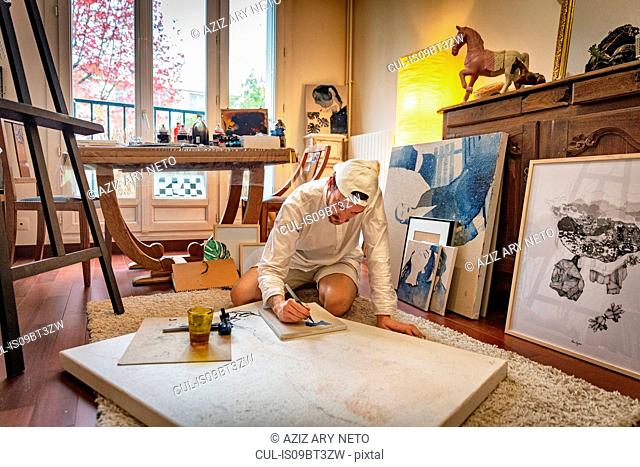 Artist working on canvas in studio