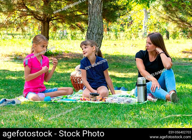 Two girls and a girl talking on a picnic