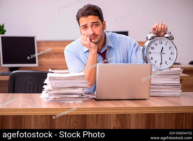 Young businessman employee unhappy with excessive work in the office