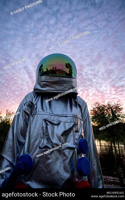 Portrait of spacewoman looking up at sunset