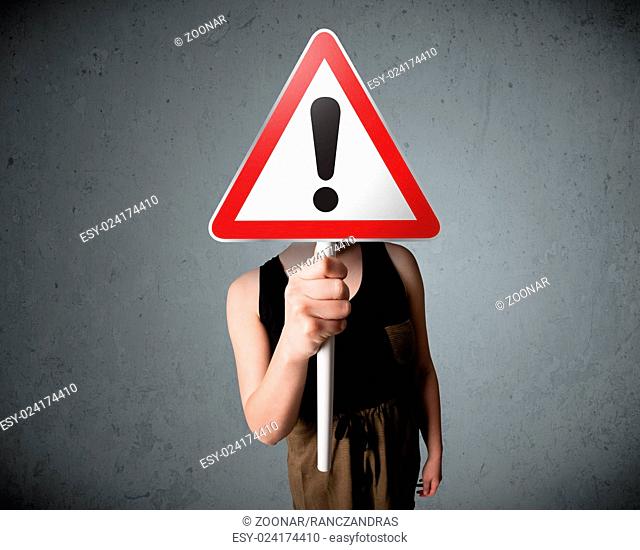 Young woman holding an exclamation road sign