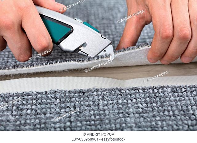 Carpenter Shaping Carpet Using Carpenter Tools To Lay Carpet At Home