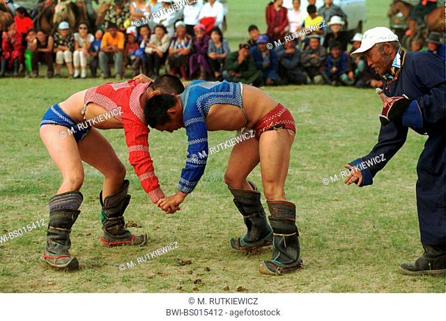 mongolian wrestler at traditional Nadaam festival, or eriyn gurvan nadaam, the annual sports festival in Mongolia, mongolian wrestlers push against each other...