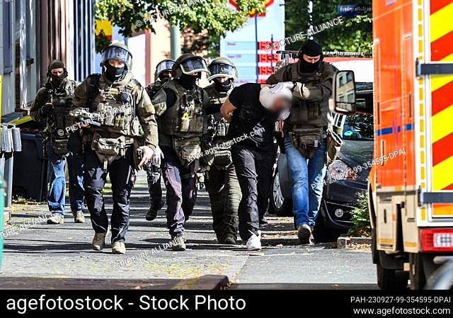 27 September 2023, North Rhine-Westphalia, Iserlohn: Special police forces take away a suspect. A homeless woman has become the victim of a homicide in Iserlohn