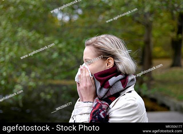 Frau niest   young blond woman with handkerchief