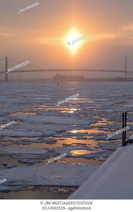 Detroit, Michigan - Ice clogs the Detroit River as the sun sets beyond the Ambassador Bridge. Frigid temperatures continue in the midwest