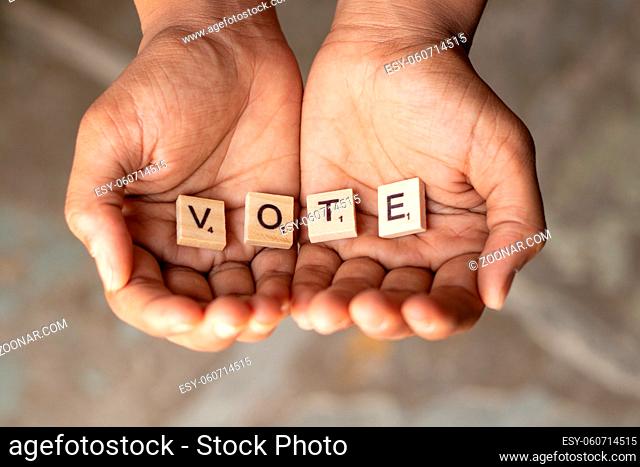 Maski, India - 14 May, 2019 : Concept of begging for votes, wooden letters in cupped hand showing gesture of begging, receiving