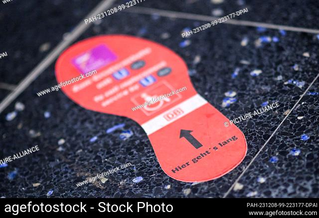 08 December 2023, Lower Saxony, Laatzen: A sticker in the shape of a foot with the inscription ""Hier geht's lang"" (""This way"") is stuck to the...
