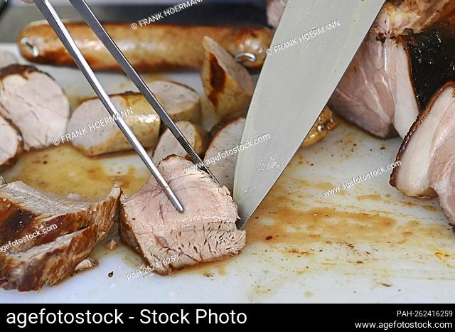Themed photo grilling. Grilled pork is portioned and cut with a meat knife. Grilling on charcoal grill, grilled meat, charcoal, charcoal grill, meat