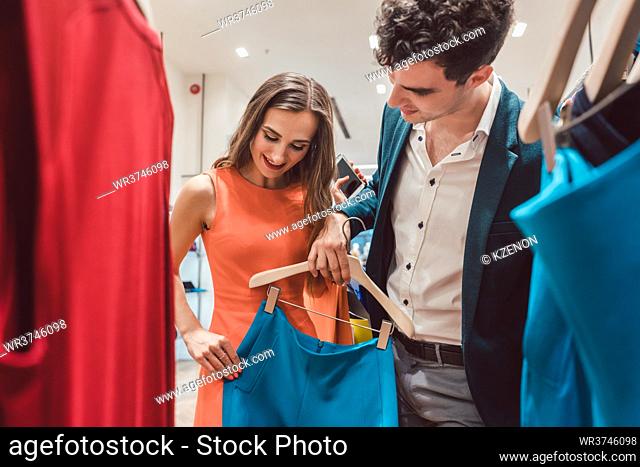 Couple craving for new clothes in fashion shopping spree testing the quality