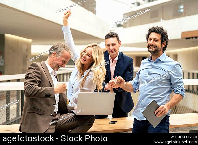 Cheerful business colleagues celebrating success at office