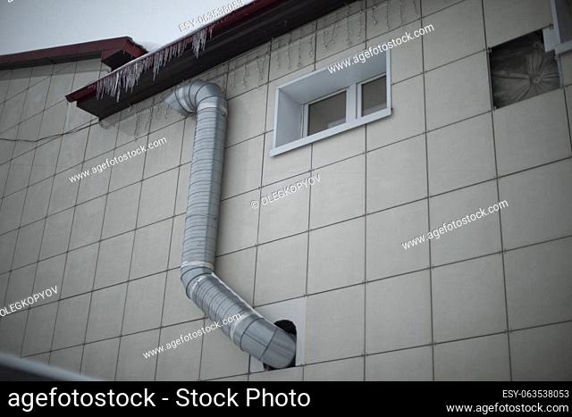 Pipe on building. Ventilation system. Building is tiled outside. Cooling in house