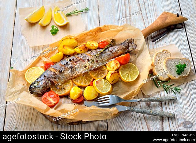 Gebackene Zitronen-Forelle mit leckerem Ofengemüse serviert auf Backpapier ? Baked lemon trout with oven-roasted rosemary potatoes and tomatoes