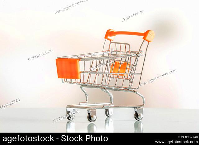Empty shopping cart in orange color in a market