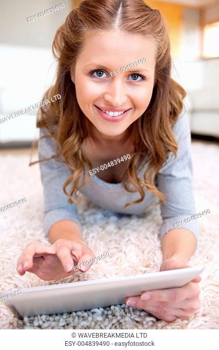 Smiling woman on the floor with her tablet