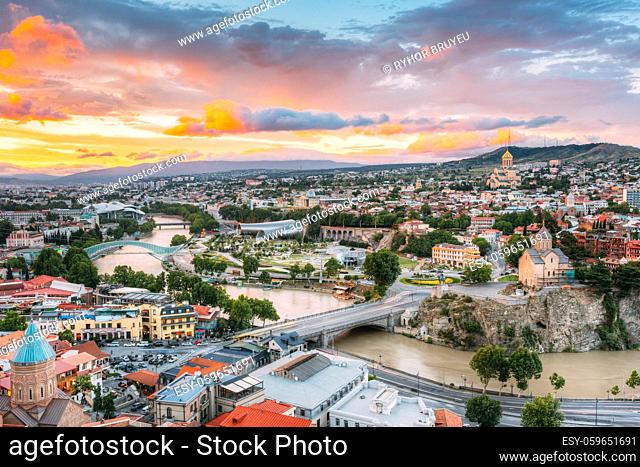 Evening View Of Tbilisi At Colorful Sunset, Georgia. Summer Cityscape. On Photograph Visible The Bridge Of Peace, A New Concert Hall