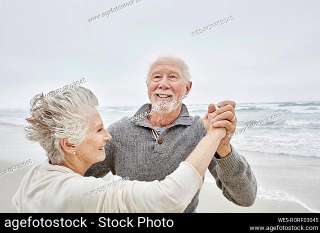 Happy senior couple dancing on the beach