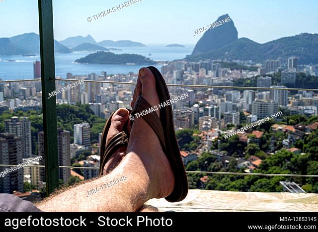 Man relaxing, view on Sugarloaf Mountain and Botafogo in Rio de Janeiro, Brazil