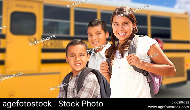 Young hispanic girl and boys walking near school bus