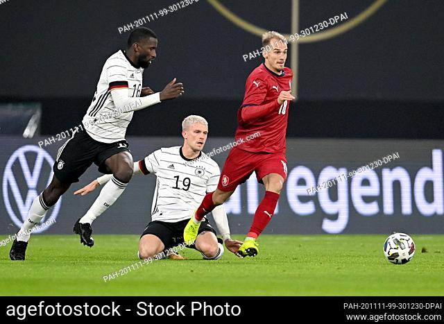 11 November 2020, Saxony, Leipzig: Football: international matches, Germany - Czech Republic in the Red Bull Arena. Antonio Rüdiger (l) and Philipp Max (M) from...
