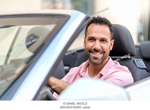 Portrait of smiling man driving convertible
