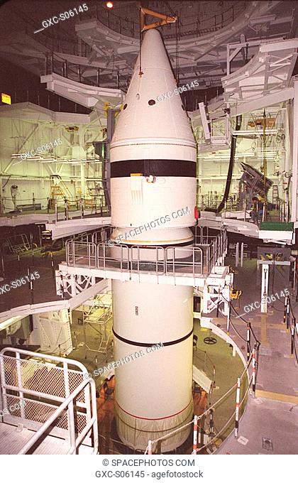 06/29/2000 --- Inside the Vehicle Assembly Building, the forward section of a solid rocket booster SRB is lowered onto the rest of the stack for mating