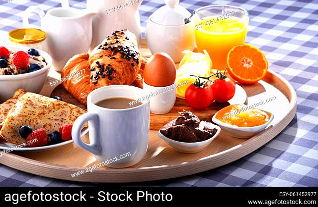 Breakfast served with coffee, orange juice, croissants, pancake, egg, cereals and fruits