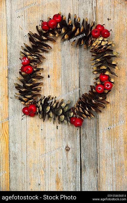 Christmas wreath of cones and berries on a wooden background