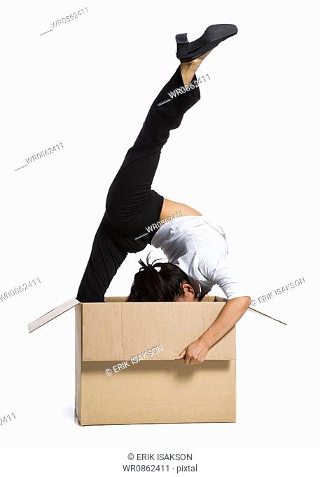 Female contortionist businesswoman inside cardboard box