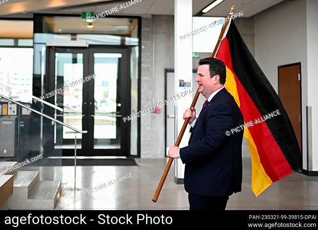 21 March 2023, Canada, Toronto: Hubertus Heil (SPD), Federal Minister of Labor and Social Affairs, holds the German flag in front of students at Humber College