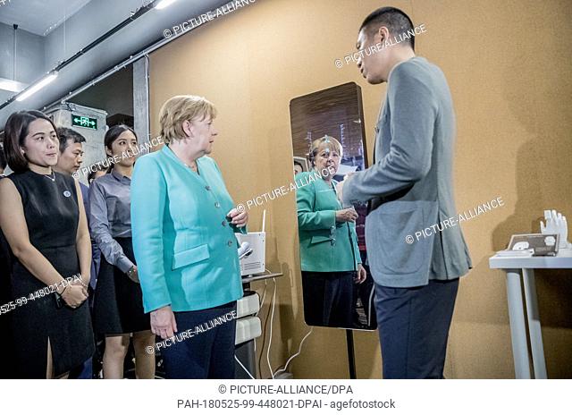 25 May 2018, China, Shenzhen: German Chancellor Angela Merkel (c) of the Christian Democratic Union (CDU) takes a tour of the start-up company iCarbonX