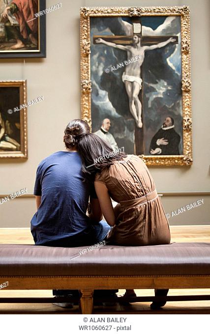 France, Paris, Young couple watching paintings in Louvre Museum