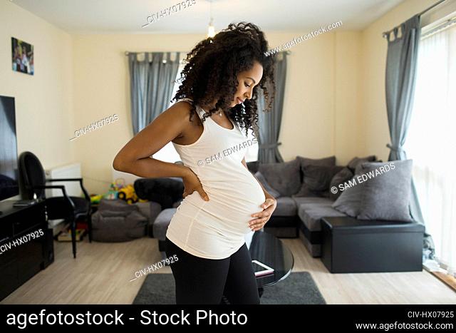 Beautiful young pregnant woman holding stomach