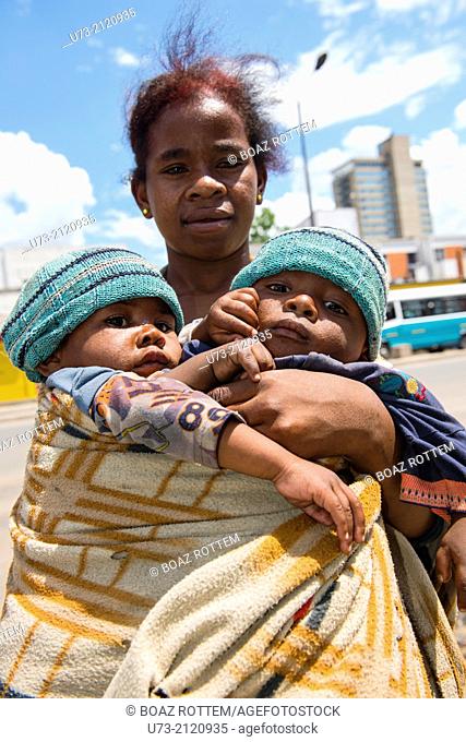A poor beggar carrying her baby twins in the streets of Antananarivo