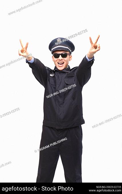 Police Officer Giving Peace Sign, Studio Shot