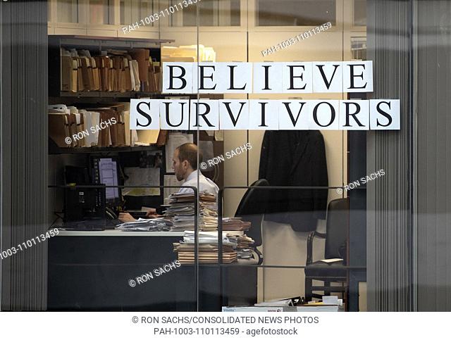 Unidentified member of a United States Senator's staff works behind signs in the window of an office that overlooks the Atrium in the Hart Senate Office...