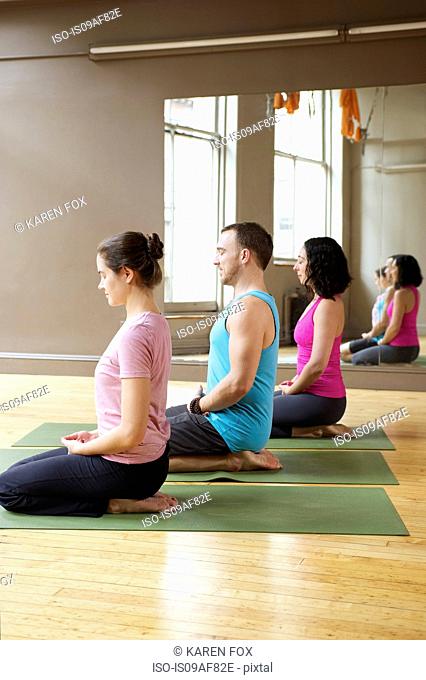 People kneeling in yoga class