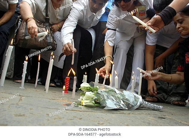 Lighting candles and flowers outside taj mahal hotel after terrorist attack by deccan mujahideen ; Bombay Mumbai ; Maharashtra ; India 26-November-2008